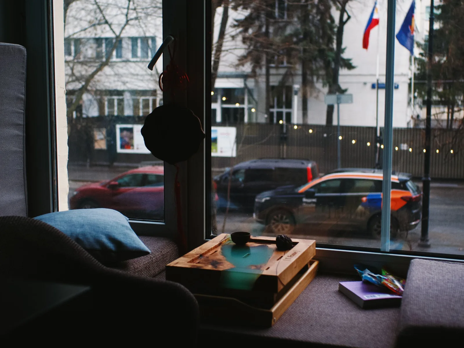 Séjour d’un appartement urbain, grande fenêtre donnant sur une rue passante.